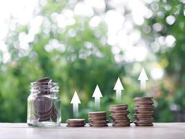 Stack of coins with arrow up icons. The concept of Financial investment, Market stock, Profit return, Dividend and Business fund. photo