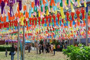Lumphun City, LPU, 2020 - Colorful perspective view of Thai Lanna style lanterns to hang in front of the temple in hundred thousand lanterns festival with people attending the tradition. photo