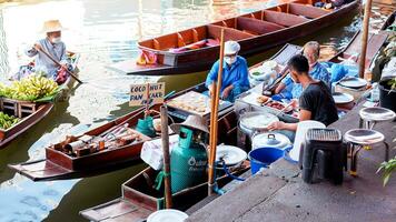 Ratchaburi City, RB, 2022 - Group of boat selling snacks and food at ancient travel destination of Thailand Damnoen saduak flating market, Ratchaburi Thailand. photo