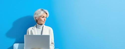 55 year old business woman with laptop on blue banner background with copy space. AI Generated photo