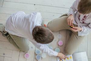 Two brothers play together. Children mold homemade from stiffening clay. Fun at home. Simple figures from plasticine do it yourself. photo