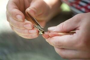 Mom gives a manicure to a child with very neglected dirty nails photo