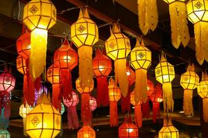 Closeup Colorful perspective view of Thai Lanna style lanterns to hanging on the ceiling and turn on light at night. photo