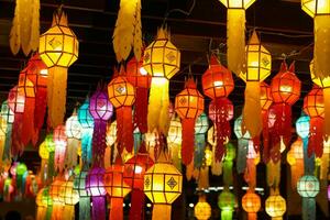 Closeup Colorful perspective view of Thai Lanna style lanterns to hanging on the ceiling and turn on light at night. photo