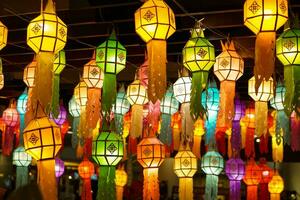 Closeup Colorful perspective view of Thai Lanna style lanterns to hanging on the ceiling and turn on light at night. photo