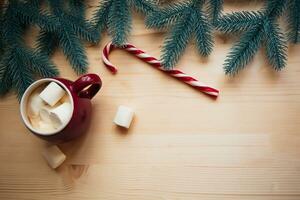 ed cups with hot chocolate or cocoa and marshmallow with sugar canes. Christmas concept with fir tree branches. Close-up, selective focus photo