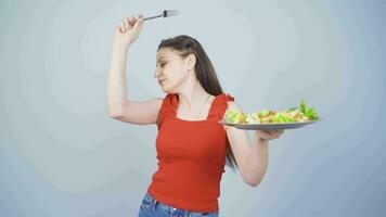 A person who diets and eats healthily. She eats salad and dances. video