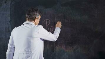 Male doctor writes Radiology on the blackboard. video