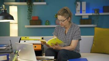 Zuhause Büro Arbeiter Frau lesen ein Buch. video