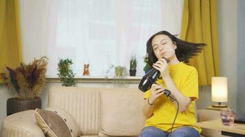 Woman singing and dancing with blow dryer. video