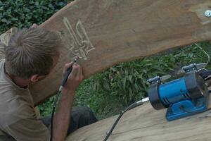 man with device cuts out coat of arms of Ukraine. photo