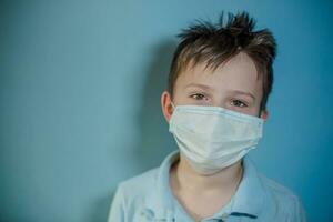 boy in medical mask on blue background. photo