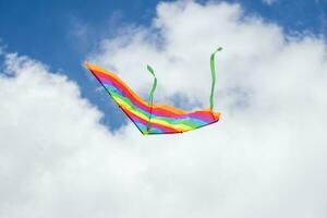 arco iris cometa volador en azul cielo con nubes en verano con copyspace foto