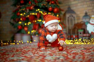 pequeño sorprendido niño en Papa Noel disfraz en festivo habitación en Navidad víspera. niña en antecedentes de Navidad árbol. foto