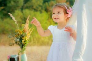 Little girl smiles and shows finger upward. A girl in a white Wigwam or play tent, children's play house photo