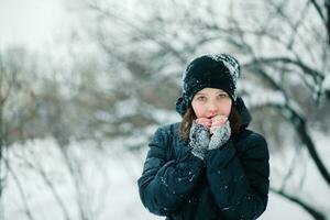 The girl is holding her hands in front of her face. Child with pink cheeks from frost. photo