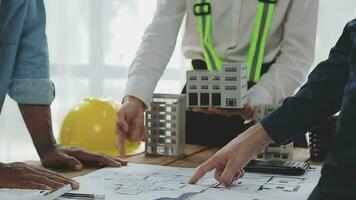 arquitetônico engenheiro equipe encontro usar do plantas, construção desenhos e cálculos para arquitetônico projetos e Engenharia Ferramentas dentro a local de trabalho técnico estrutura conceito. video