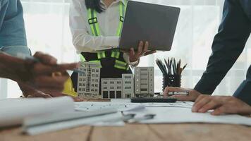 bouwkundig ingenieur team vergadering gebruik van blauwdrukken, bouw tekeningen en berekeningen voor bouwkundig projecten en bouwkunde gereedschap in de werkplaats technisch structuur concept. video