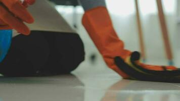 Housewife using vacuum cleaner on the floor. Wearing an apron to clean the living room at house. Young woman is happy to clean home. Maid cleaning service. video