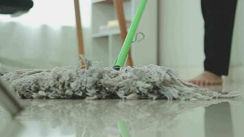 Hausfrau mit Vakuum Reiniger auf das Boden. tragen ein Schürze zu sauber das Leben Zimmer beim Haus. jung Frau ist glücklich zu sauber heim. Maid Reinigung Service. video