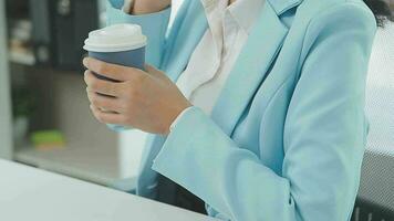 Beautiful Asian woman sitting in the office using a laptop. Happy business woman smiling and enjoying her work and taking note on a notepad. video