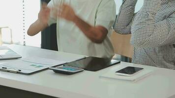 multiétnico grupo do feliz o negócio pessoas trabalhando junto, encontro e debate dentro escritório usando computador, computador portátil, tábua, e Móvel telefone. video