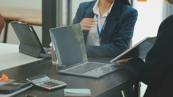 multietnico gruppo di contento attività commerciale persone Lavorando insieme, incontro e di brainstorming nel ufficio utilizzando computer, computer portatile, tavoletta, e mobile Telefono. video