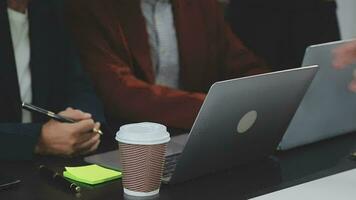 multietnico gruppo di contento attività commerciale persone Lavorando insieme, incontro e di brainstorming nel ufficio utilizzando computer, computer portatile, tavoletta, e mobile Telefono. video