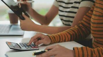 multietnico gruppo di contento attività commerciale persone Lavorando insieme, incontro e di brainstorming nel ufficio utilizzando computer, computer portatile, tavoletta, e mobile Telefono. video