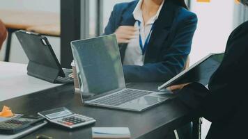 multietnico gruppo di contento attività commerciale persone Lavorando insieme, incontro e di brainstorming nel ufficio utilizzando computer, computer portatile, tavoletta, e mobile Telefono. video