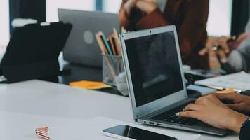 multi-etnisch groep van gelukkig bedrijf mensen werken samen, vergadering en brainstorming in kantoor gebruik makend van computer, laptop, tablet, en mobiel telefoon. video