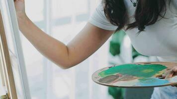 atractivo joven mujer asistiendo un pintura taller, teniendo divertido, crear un inspirado Arte trabajo a Arte estudio video