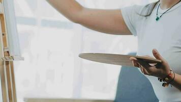 atractivo joven mujer asistiendo un pintura taller, teniendo divertido, crear un inspirado Arte trabajo a Arte estudio video