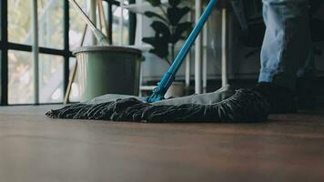 huisvrouw gebruik makend van vacuüm schoonmaakster Aan de vloer. vervelend een schort naar schoon de leven kamer Bij huis. jong vrouw is gelukkig naar schoon huis. hulp in de huishouding schoonmaak onderhoud. video