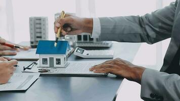 bostadsköpare träffar och förhandlar med fastighetsmäklare om att hyra eller köpa en bostad på kontoret. video