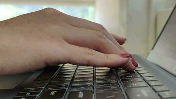 Close up side view of female hands of typing keyboard on laptop at office desk. concept of working online with pc software apps technology video