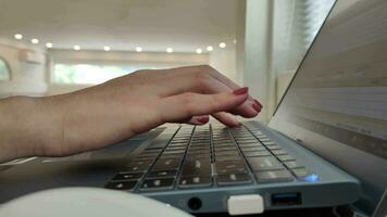 Close up side view of female hands of typing keyboard on laptop at office desk. concept of working online with pc software apps technology video