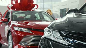 Female customer choosing new car at the dealership showroom video