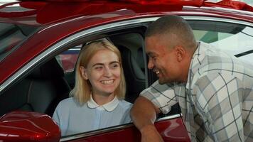 Cheerful young couple buying new automobile video