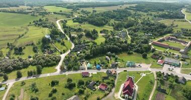 panoramique aérien vue et vol plus de éco village avec en bois Maisons, gravier route, jardins et vergers video