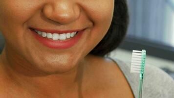 Happy woman with perfect smile holding toothbrush near her mouth video