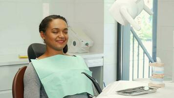 Young woman smiling showing thumbs up waiting for dental checkup video