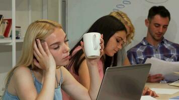 Young businesswoman looking tired while working with her team video