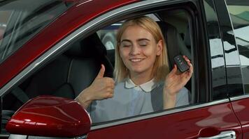 Lycklig kvinna förare som visar henne bil nycklar och tummen upp video