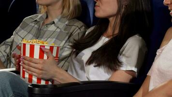 Three female friends watching movies at the cinema video