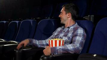 content Beau homme souriant joyeusement séance à le cinéma video