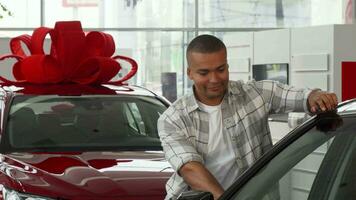 Happy handsome African man showing car keys to his new auto video