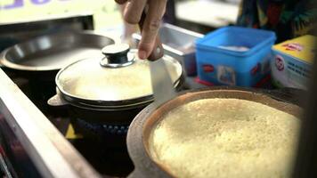 Surabaia, Indonésia, outubro 09, 2023 - rua vendedores preparar a processo do fazer doce martabak de elevação a cozinhou massa. video