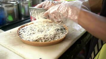 Surabaia, Indonésia, outubro 09, 2023 - processo do fazer com sabor de queijo doce martabak de aspersão raspada queijo em topo do a massa. video