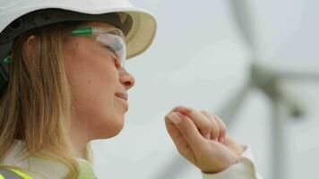 Wind turbines are the future of energy a woman in a helmet and goggles carefully examines generators for a renewable power plant. Wind turbines for a sustainable future an engineer coordinates the video